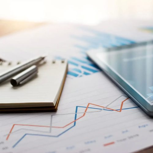 Finanzberichtsanalyse mit Tablet, Diagrammen auf Papier und Stift auf Notizbuch für geschäftliche Planung, Investitionen und Strategie.